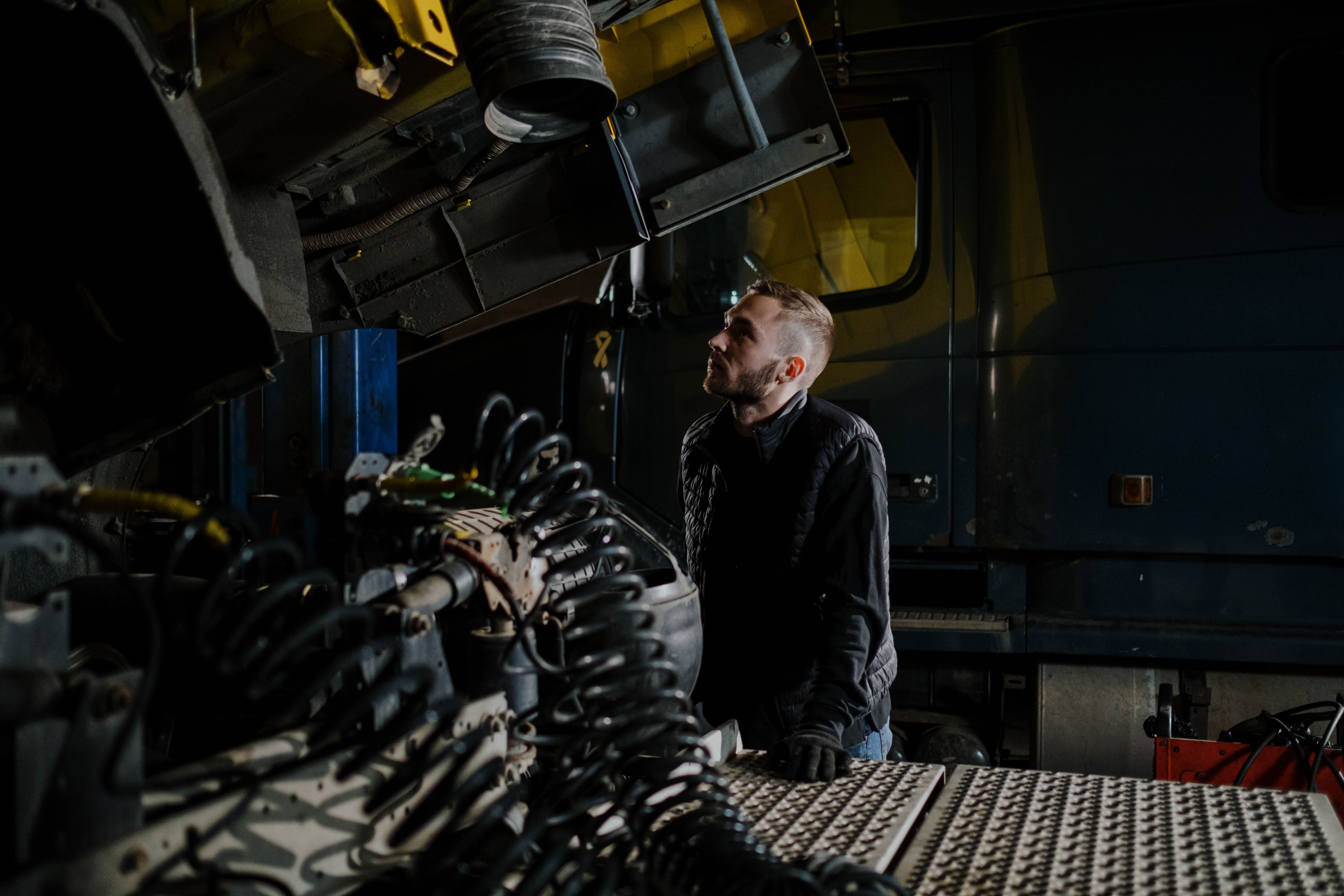 Truck mechanic examining a diesel engine inside a repair garage