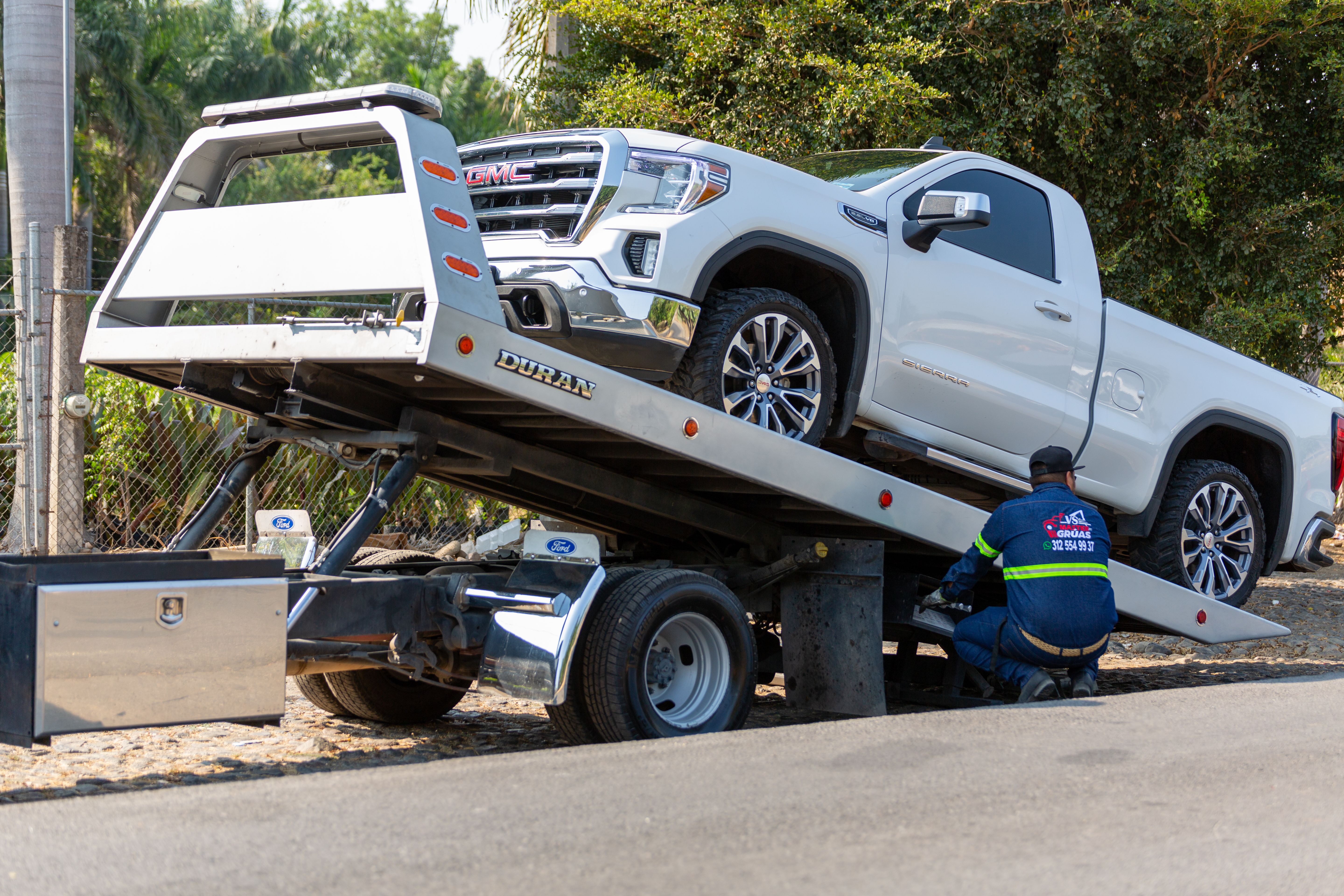 Tow truck operator loading a vehicle for roadside assistance